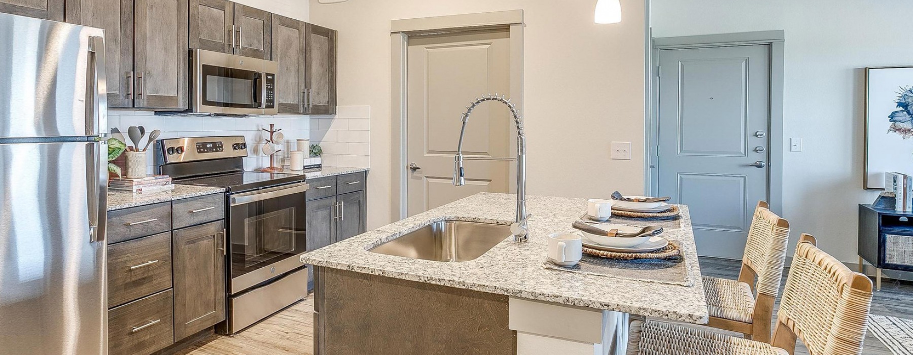 Well-lit kitchen with ample counter space in units at Chisholm Trace Apartments